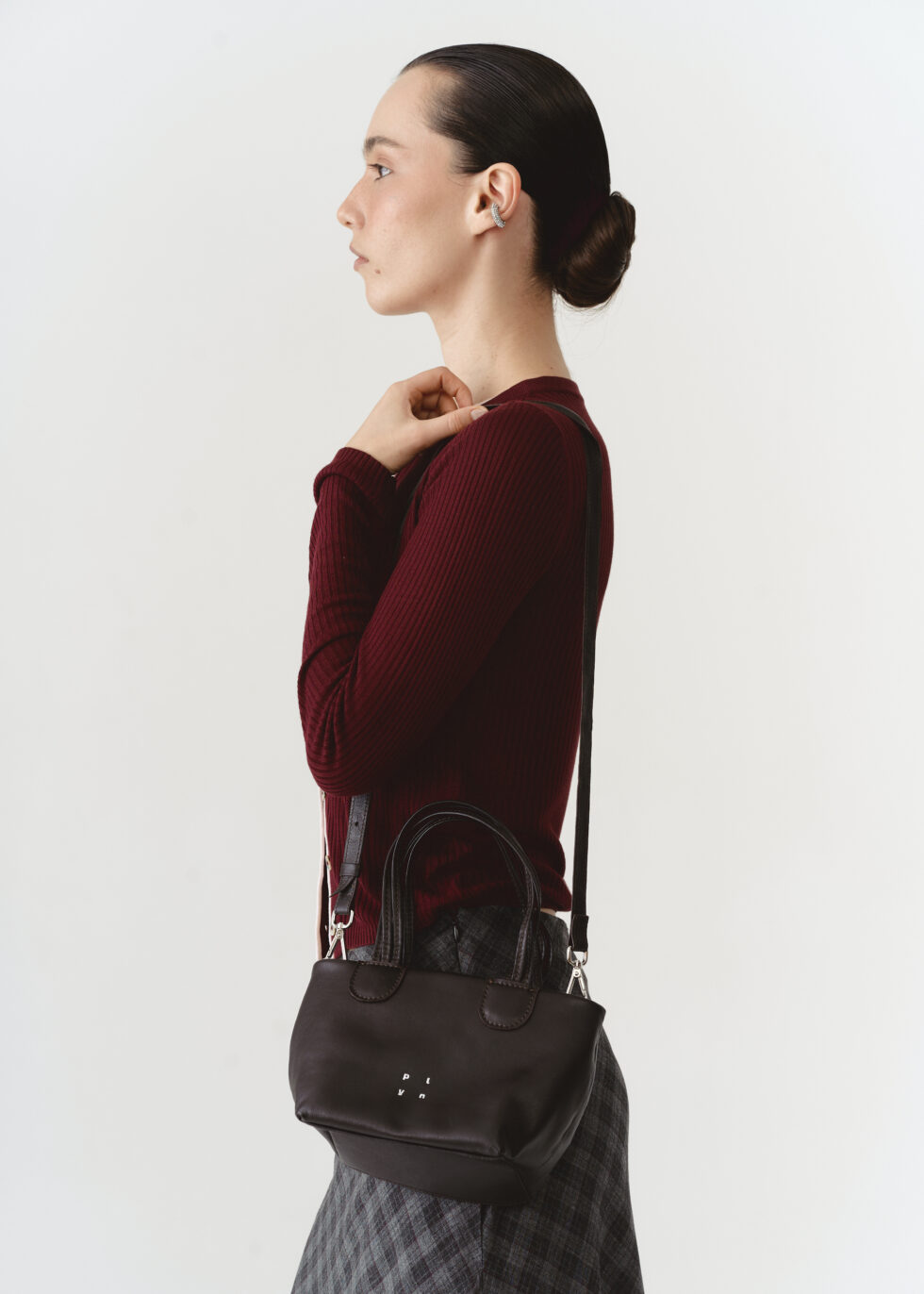 Коричнева шкіряна кросбоді з плетеними ручками на плечі моделі