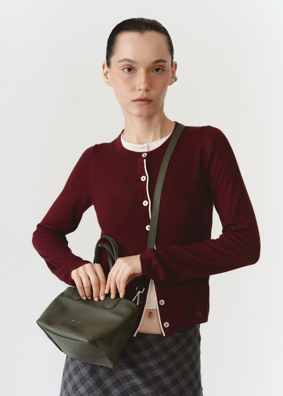 Шкіряна кросбоді хакі з плетеними ручками через плече моделі